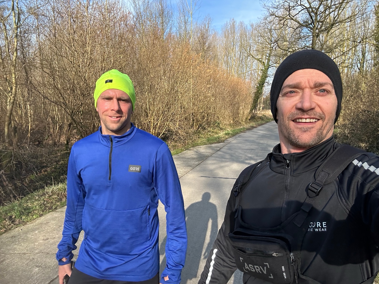 Twee lopers samen op een zonnige landweg in de winter