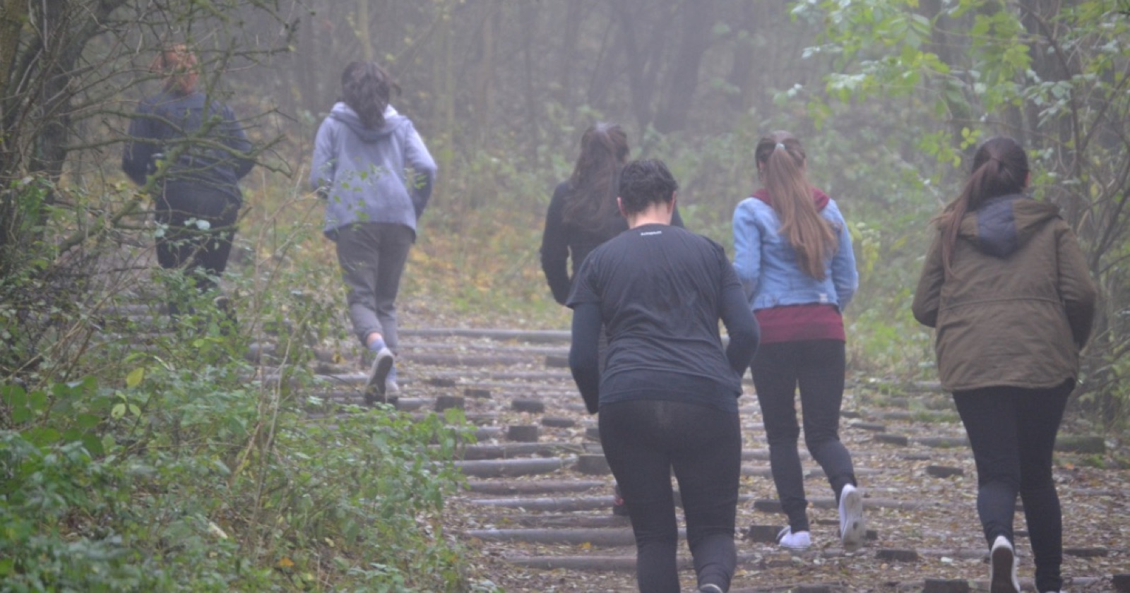 Groep RUNIT-lopers op een mistig bospad