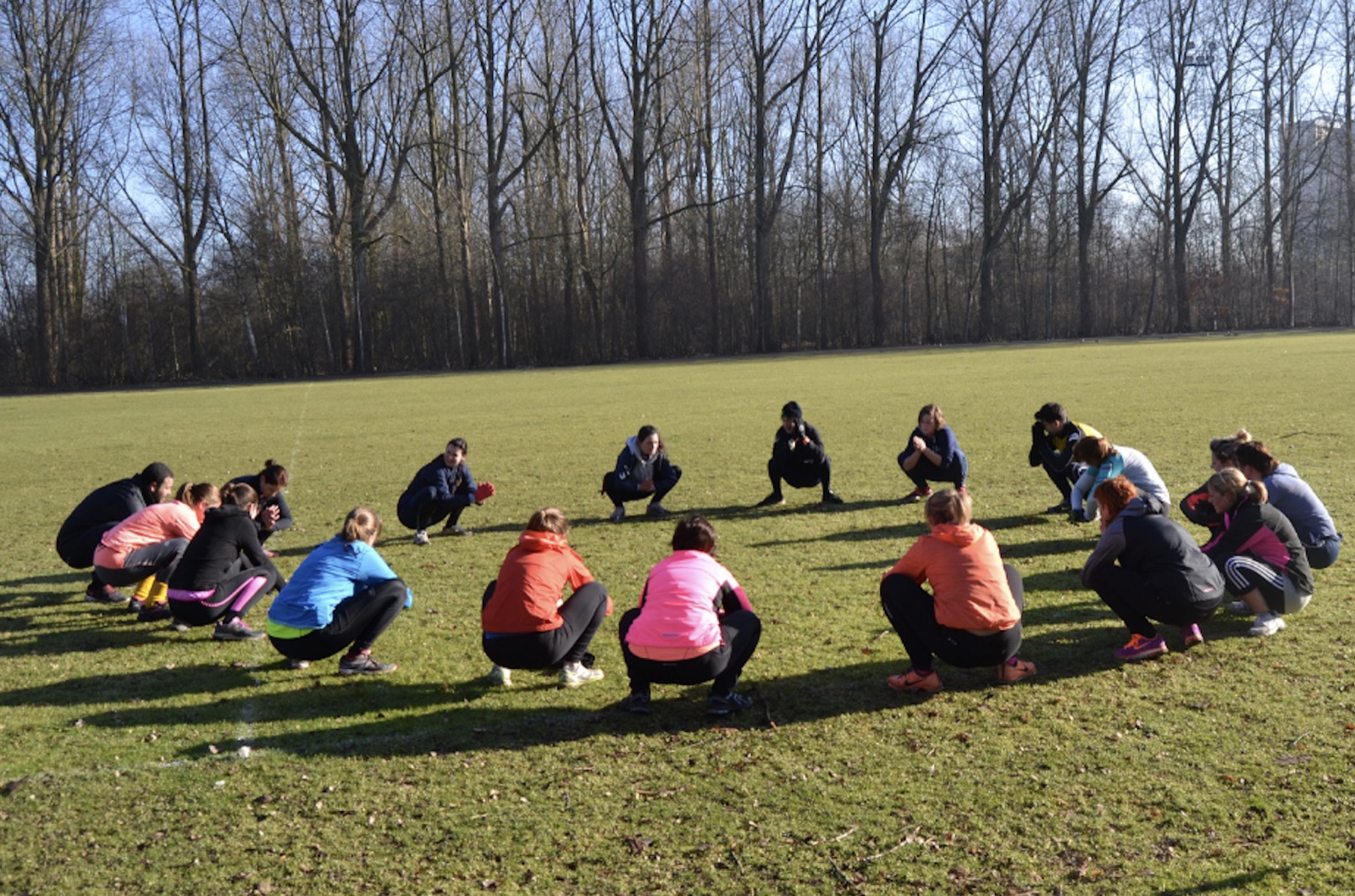 Groep RUNIT-lopers samen aan het stretchen op het veld